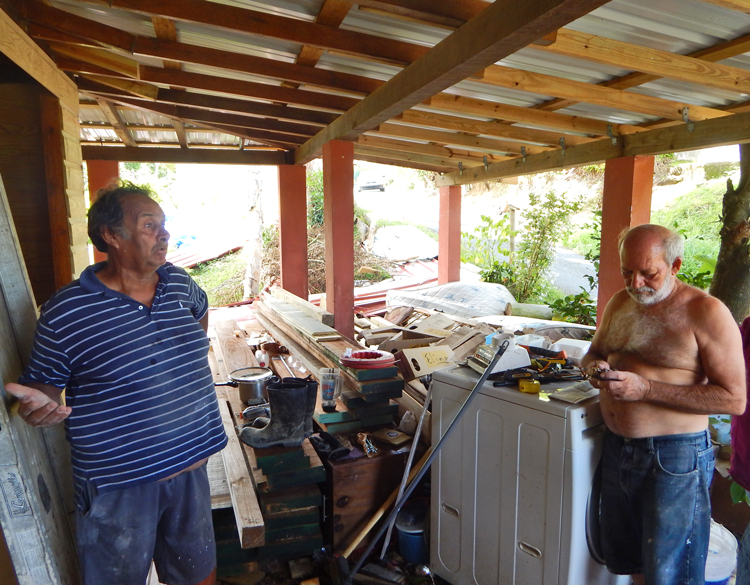 Electricista Raúl Laboy (izq.) y Wilfredo Abreu, en Humacao, Puerto Rico, en un descanso de su labor de reconstrucción. “El huracán social” del capitalismo es peor que el natural, dijo Laboy.
