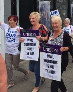 Hospital workers march in Wigan, England, June 9 during 48-hour strike over jobs transfer, new two-tier pay.