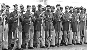 Above, Black troops in Union Army, most freed slaves, in Second American Revolution. Some 200,000 fought, many taking on the most daring tasks. Inset, Black troops run an artillery battery.