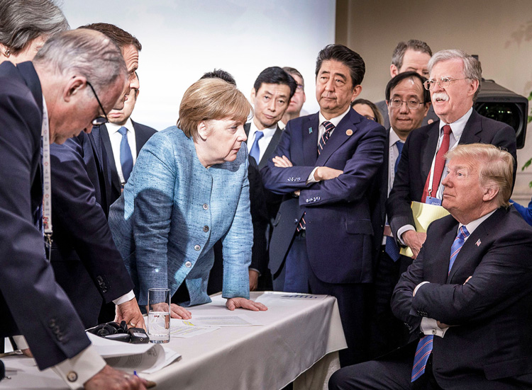 Donald Trump, Angela Merkel and other capitalist rulers stand off during G-7 summit June 9. Tensions are product of crisis of capitalism, which sharpens competition between rivals.