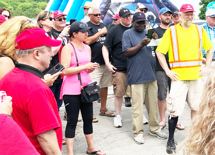Mineros de la sal en huelga discuten progreso de negociaciones en línea de piquetes frente a mina de Compass Minerals en Goderich, Ontario, el 13 de julio, antes de ganar nuevo contrato.