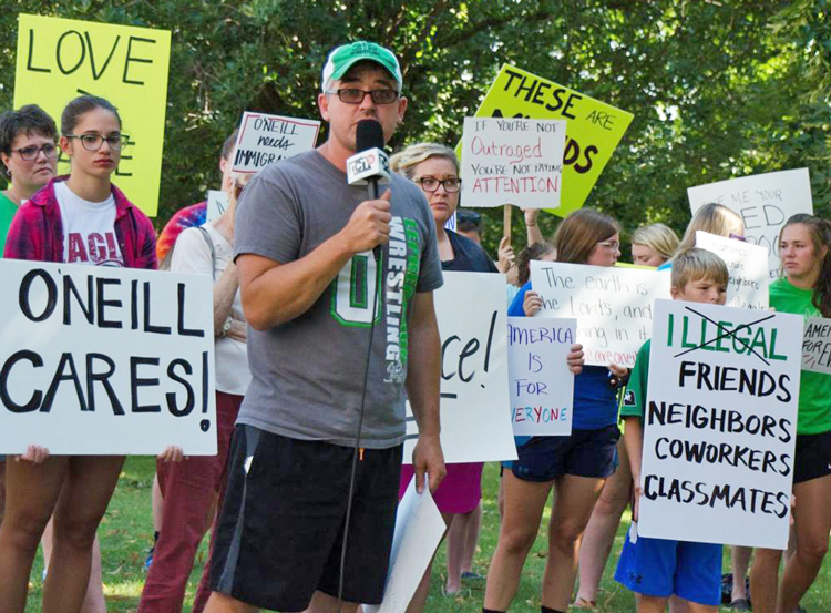 Entrenador de lucha libre Bryan Corkle habla en protesta en O’Neill, Nebraska, contra arrestos y deportaciones de trabajadores durante redada de ICE en fábricas y granjas aledañas.