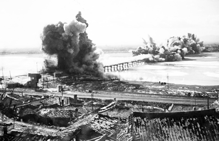 U.S.-organized United Nations forces destroy bridge near Hamhung, North Korea, to prevent its use, Dec. 19, 1950. Imperialist troops were driven back by DPRK forces and Chinese volunteers. Washington used its massive airpower to destroy virtually every building in the North.