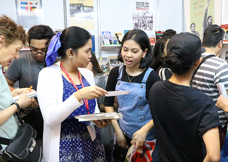 Manila book fairgoers crowd into Pathfinder booth featuring books by revolutionary leaders.