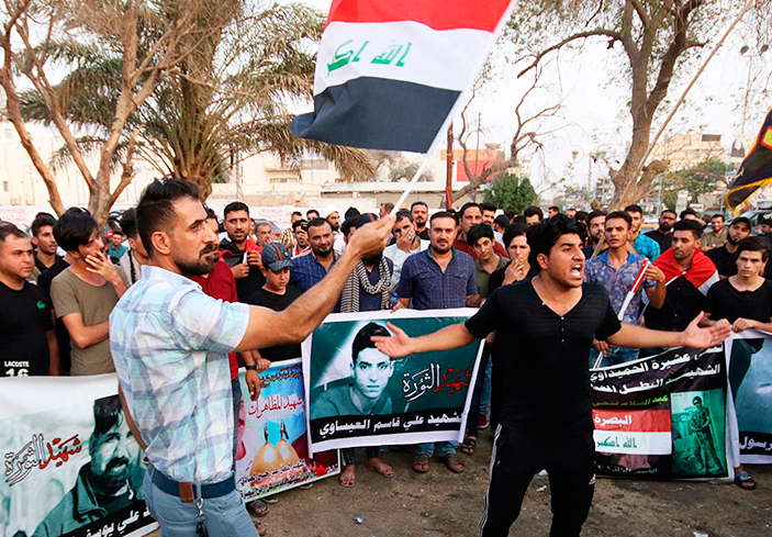 Demonstrators Sept. 12 in Basra hold Iraqi flags and images of protesters killed at previous actions demanding water, electricity, jobs and an end to Iranian interference in the country.