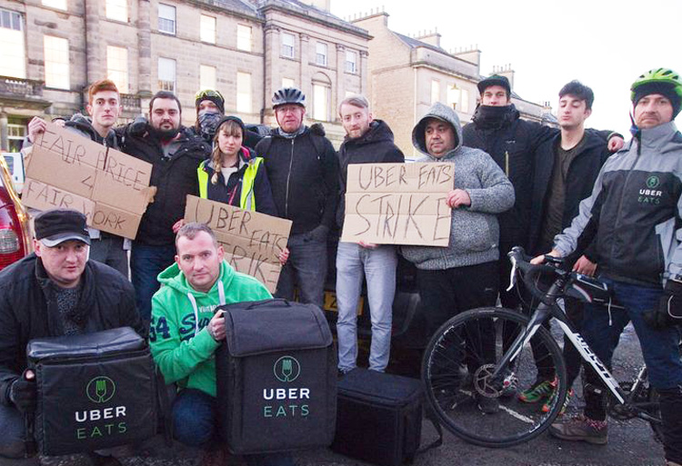 Couriers from Uber Eats in Edinburgh, Scotland, on strike in January against long hours and low pay. App-based bosses and taxi companies profit in pitting drivers against each other.