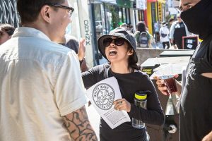 Demonstration against Weird Wave Coffee shop. Leaflet says, “White wave. Get out, sellouts.”