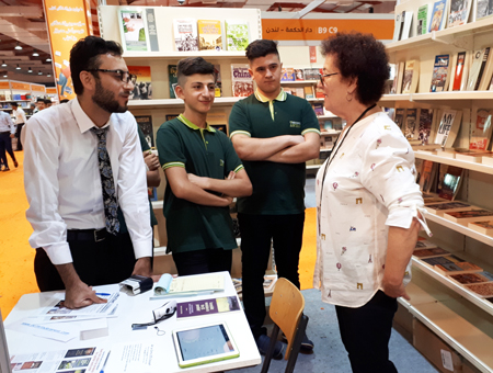 Volunteer Carole Lesnick speaks with visitors to Pathfinder booth, a hive of discussion of politics and the class struggle in the U.S., U.K., Middle East and worldwide. 