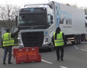 Yellow vest protesters stop truck Dec. 11 in Dieppe, a coastal town in Normandy region of northern France. Cars and buses were allowed to pass. “Macron thinks those who labor are dumb,” protester Nathalie Girard told U.K. Communist League member Debra Jacobs, “but the opposite is the case. The work we do — that’s intelligence, that’s creativity.”