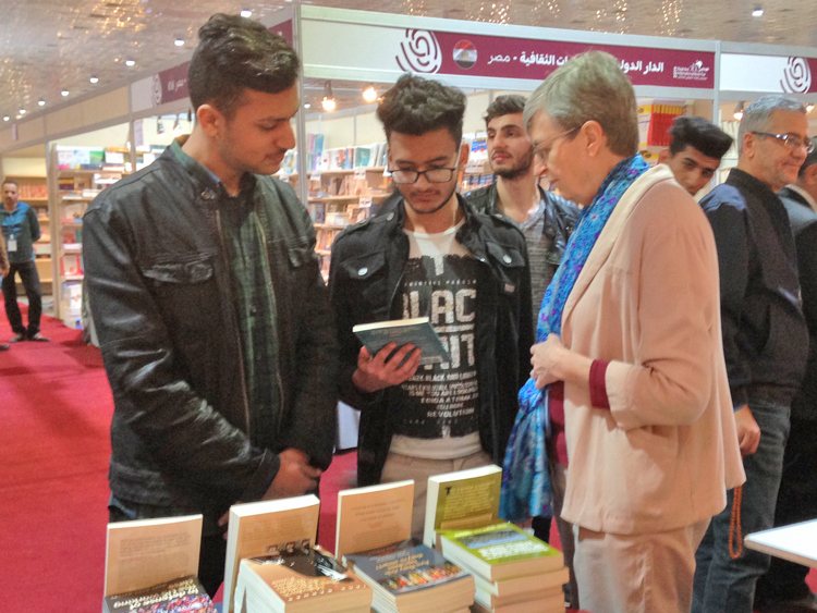 Catharina Tirsén discusses books by Socialist Workers Party leaders with Iraqi youth at Baghdad book fair Feb. 7. Event attracted thousands seeking reading after years of wars and repression.