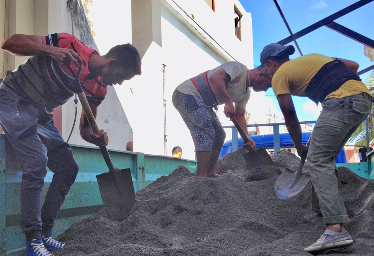 Estudiantes voluntarios preparan cemento con trabjadores de la construcción el 2 de febrero, parte de esfuerzos para reparar el policlínico dañado por el tornado en el distrito Diez de Octubre de La Habana.
