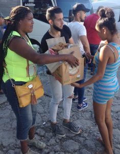 Voluntarios distribuyen ropa y zapatos a residentes del barrio Regla afectado por el tornado.