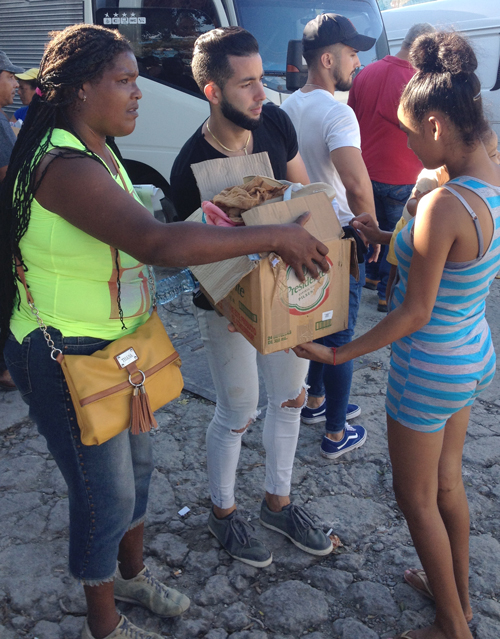 Volunteers provide solidarity, distributing clothing and shoes to residents of tornado-hit Regla neighbor-hood in Havana. 