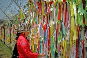 Woman reads ribbons urging peace and reunification of North and South Korea at Demilitarized Zone, May 24, 2018. President Trump and North Korean leader Kim are set to meet Feb. 27.