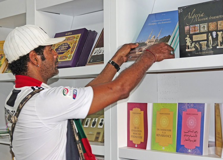At Havana International Book Fair, where Algeria is country of honor, Oscar Creach Wenclar browses books at Algeria pavilion Feb. 11. He was proud that his father was one of nearly 700 Cuban volunteers who went to Algeria in 1963 to help defend the newly independent nation against imperialist-backed invasion by Moroccan troops