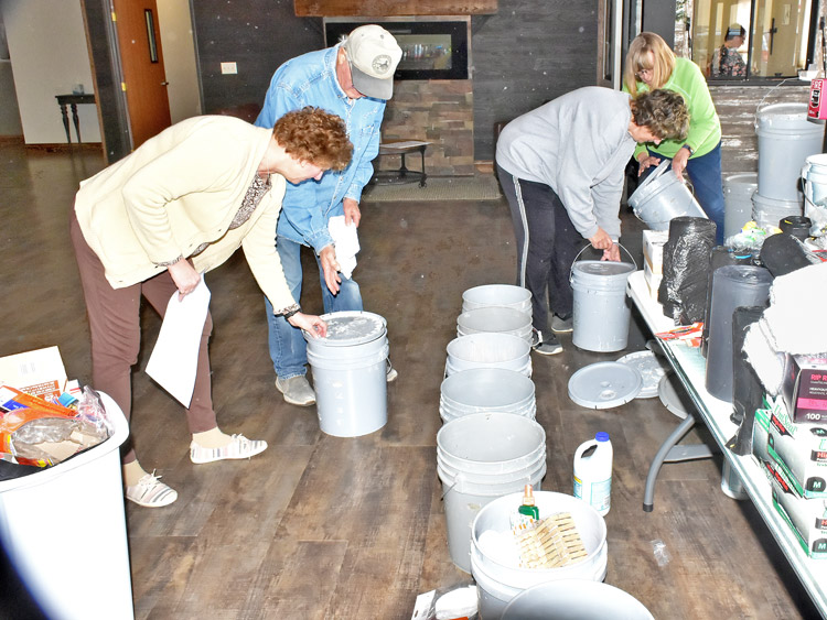 Voluntarios en McCook, Nebraska, se organizan para llenar cubetas con víveres para enviar a áreas afectadas por inundaciones. El gobierno ha dejado abandonados a los damnificados.