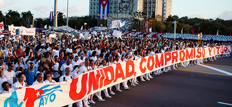 Hundreds of thousands of people march during May Day rally in Havana to protest U.S. threats. Banner says, “Unity, Commitment and Victory.”