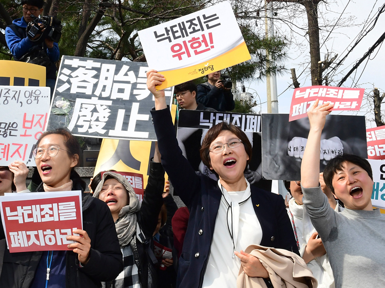 Rally in Seoul April 11 celebrates South Korea’s high court ruling that country’s ban on abortion is unconstitutional. Signs say, “Abortion law should be abolished” and “is unconstitutional.”