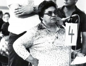 Joyce Meissenheimer speaks at 1980 British Columbia New Democratic Party convention, wearing button defending Pratt Three, three women workers fired by Pratt & Whitney aerospace factory after Canadian rulers’ political police told bosses they were communists.