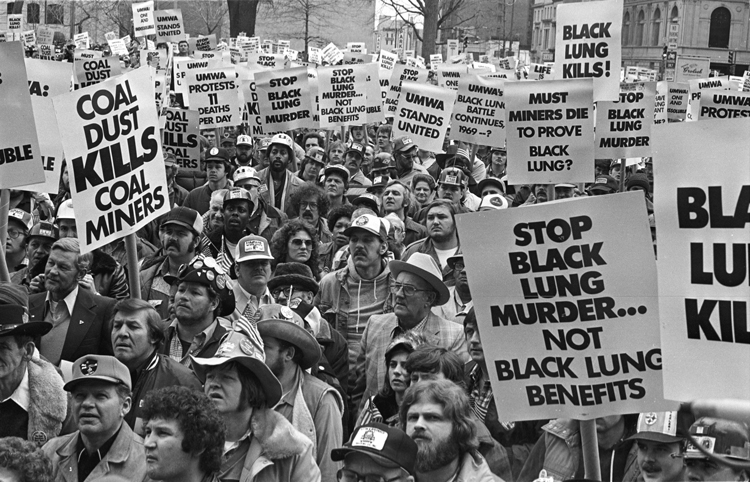 Top, miners block rails, Harlan County, Kentucky, July 2019, to stop Blackjewel bosses from hauling coal until wages owed them were paid. The nonunion miners won broad support and, in October, their back pay. Above, miners hold national protest in Washington, D.C., March 1981, a few weeks before 160,000 began 10-week strike, turning back concession contract demanded by mine bosses.