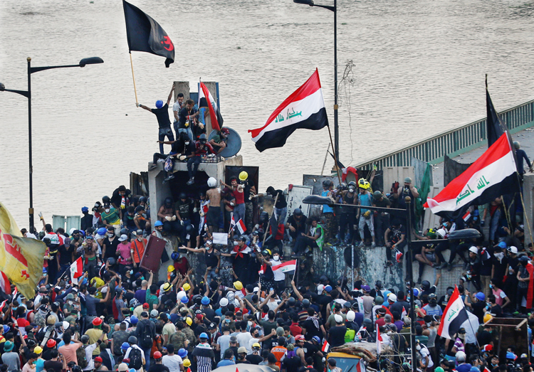 Manifestantes se congregan en el puente Al Jumhuriya en Bagdad el 29 de octubre, el quinto día de protestas contra injerencia iraní, corrupción del gobierno, y medidas antiobreras.