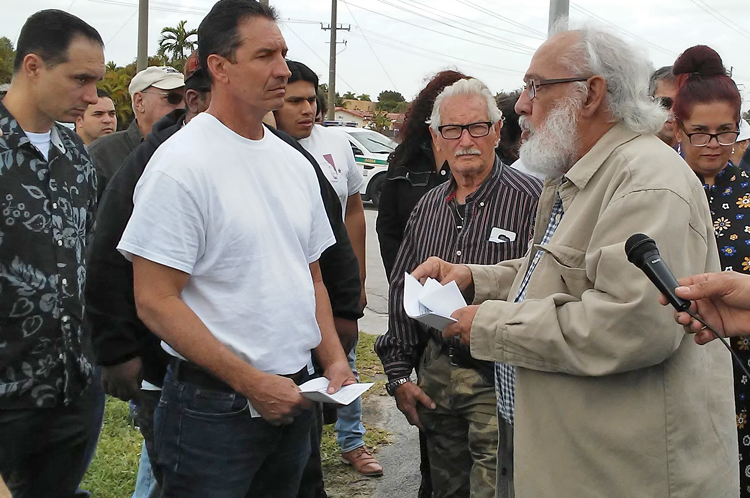 Andrés Gómez, right, leader of Alianza Martiana, speaks before 50-car caravan wound its way through Miami’s Little Havana Feb. 8, calling for end to new U.S. attacks on travel to Cuba.
