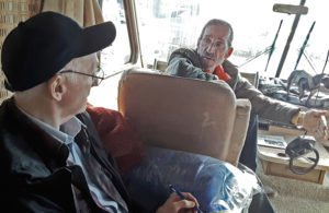 Joel Britton, left, currently SWP candidate for U.S. Congress, speaks with carpenter Tony Worino in his RV at Camp Fire refugee camp in Chico, California, in December 2018.