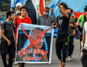 Anti-government demonstrators in Baghdad April 9 march against appointment of Mustafa al-Kadhemi, Iraq government’s spy master, as prime minister, with his picture crossed out.