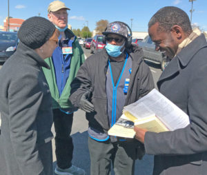 Socialist Workers Party presidential candidate Alyson Kennedy, left, and vice presidential candidate Malcolm Jarrett, right, speak with Walmart worker Otis Bullock in Philadelphia.