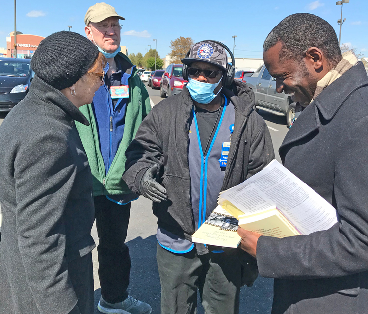 Socialist Workers Party presidential candidate Alyson Kennedy, left, and vice presidential candidate Malcolm Jarrett, right, speak with Walmart worker Otis Bullock in Philadelphia.
