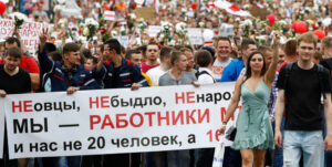 Thousands of working people march from Minsk tractor factory to Belarus parliament Aug. 14. Banner answers President Lukashenko’s attacks, saying: “We’re not sheep. ... We are MTZ workers, we are not 20 people, we are 16,000!” Inset, like many disgusted at violent attacks on demonstrators, soldier had himself filmed throwing his uniform away into the garbage.