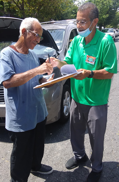 Campaign supporter Nelson Gonzalez, at right, signs people up in Bayonne, New Jersey.