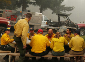 A few of the 1,200 workers in the “Hillbilly Brigade” who volunteered to fight fires gather for a meal at Hansen family farm after battling the Riverside Fire near Molalla, Oregon, Sept. 16.