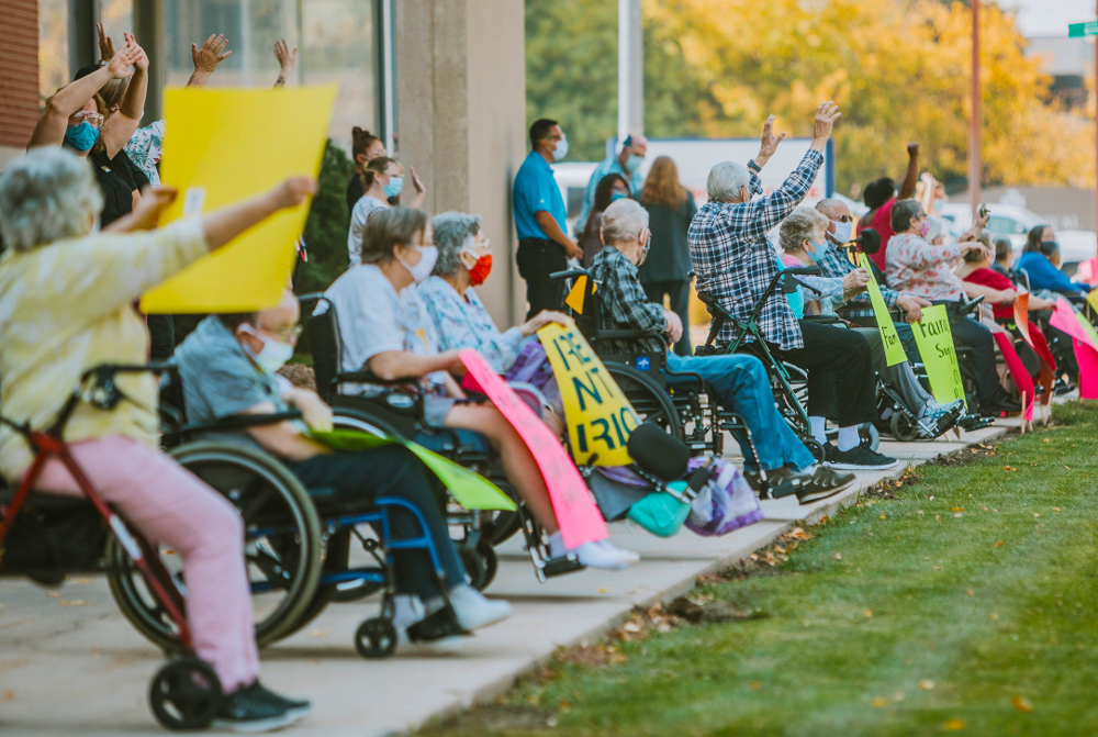 Fairacres Manor nursing home residents in Greeley, Colorado, backed by nursing staff, protest restrictions imposed on physical contact with loved ones Oct. 8. Rulers have shunted elderly into overcrowded, understaffed nursing homes, leaving thousands shut in to die.