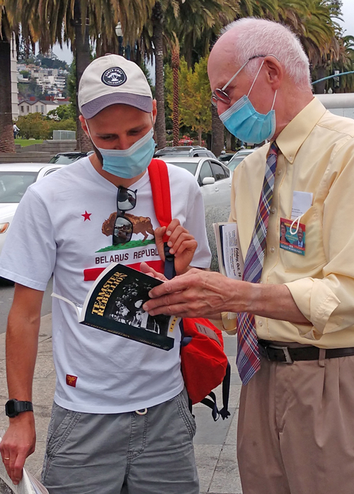 Joel Britton, right, SWP candidate for 13th Congressional District in California, shows Teamster Rebellion, story of hard-fought strikes that built a union and made Minneapolis a union town, to participant in Oct. 10 San Francisco demonstration in solidarity with struggle to bring down Lukashenko regime in Belarus.