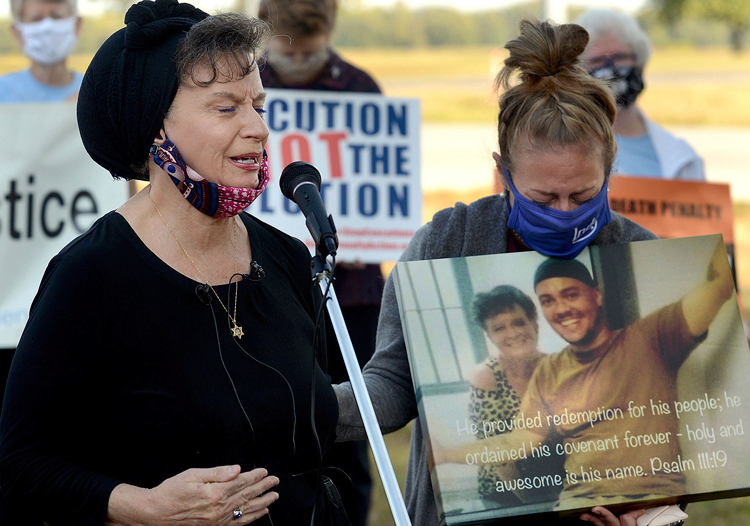 Lisa Brown, mother of Christopher Vialva, speaks at anti-death-penalty rally Sept. 24 at federal prison in Terre Haute, Indiana, hours before her son was executed. Poster shows his picture.