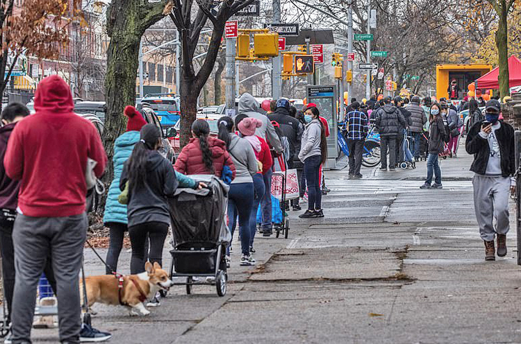 People wait in long lines at food bank in Bushwick in Brooklyn, N.Y., Nov. 26, for Thanksgiving dinner food. Many workers are forced to turn to food banks today for first time in their lives. 