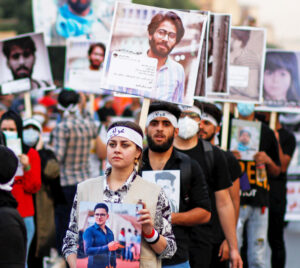 Protesters in Baghdad, Iraq, Oct. 28, 2020, carry photos of some of 600 people killed by security forces during anti-government actions.