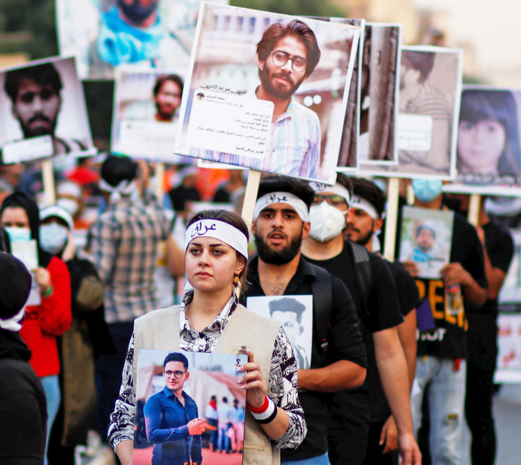 Protesters in Baghdad, Iraq, Oct. 28, 2020, carry photos of some of 600 people killed by security forces during anti-government actions.