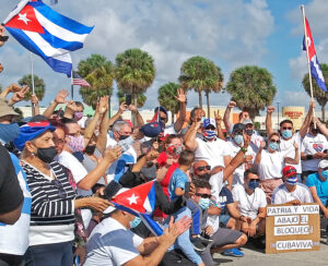 Some of the participants from March 28 caravan protest in Miami rally at the end of a drive through Coral Gables and the “Little Havana” area of the city. Placard at right says, “Homeland and life! Down with the blockade! Long live Cuba.” Action was fourth straight monthly protest