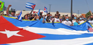 Above, participants in Miami caravan rally around Cuban flag April 25 after caravan through Little Havana.