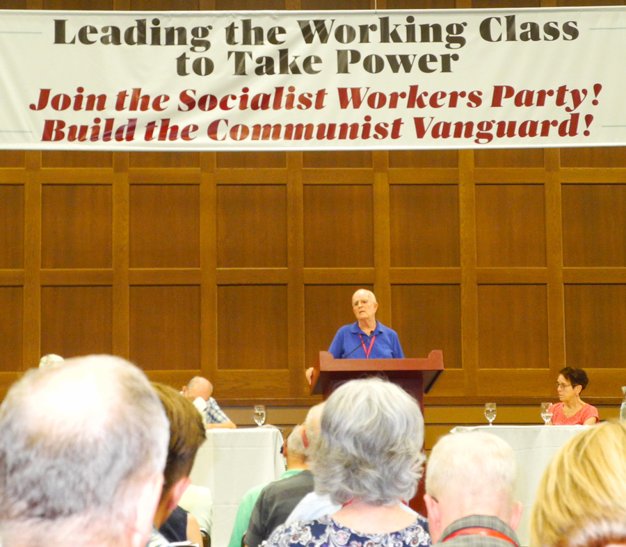 Jack Barnes, SWP national secretary, speaks at conference. SWP leader Mary-Alice Waters, right. Banner captured central themes of conference presentations, classes, discussions.