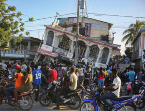 People gather outside Petit Pas Hotel, destroyed by Aug. 14 earthquake in Les Cayes, Haiti. Impoverished by U.S. imperialist plunder, thousands were killed, injured or made homeless. 