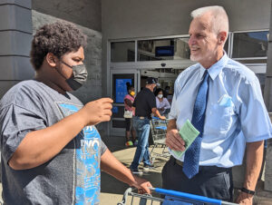 Dennis Richter, right, SWP candidate for governor of California, talks with high school student Marcus Connelly at L.A. Walmart Aug. 5. Connelly said U.S. government should have made sure everyone could get vaccinated and jabs were given “to poor countries around the world.”