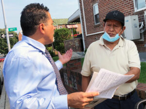Róger Calero, SWP candidate for New York mayor, discusses disaster for workers from tropical storm flooding with Luis Rosas, retired maintenance worker in Woodside, Queens, Sept. 12.