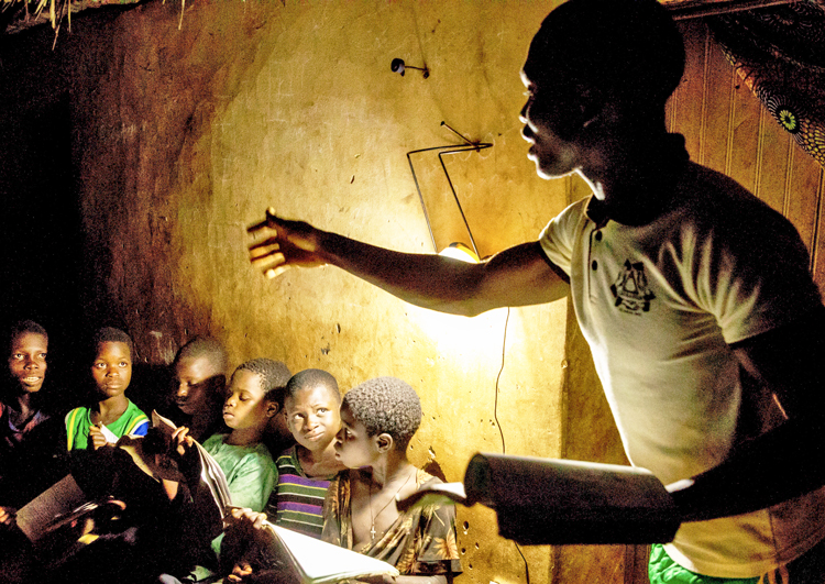 Students study by solar lamp in Benin in 2017. While 700 million people worldwide lack access to electricity, anti-working-class environmental schemes call for ban on new power plants.