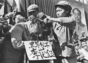 Red Guards, instigated by Mao Zedong, in poster on right, publicly humiliate official during 1966-76 anti-working-class Cultural Revolution in China. Fidel Castro said Mao and the Chinese Communist Party’s counterrevolutionary policies led Beijing to an alliance with U.S. imperialism and “brutal attacks” against the heroic peoples of Vietnam, Angola and Cuba.