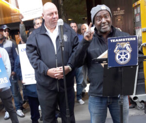 Teamsters Local 553 members on strike against United Metro Energy in Brooklyn rally Oct. 19 at Manhattan offices of owner John Catsimatidis. Speaking is picket captain André Soleyn. Unionists are demanding wage raise to match prevailing pay in the industry in New York area.