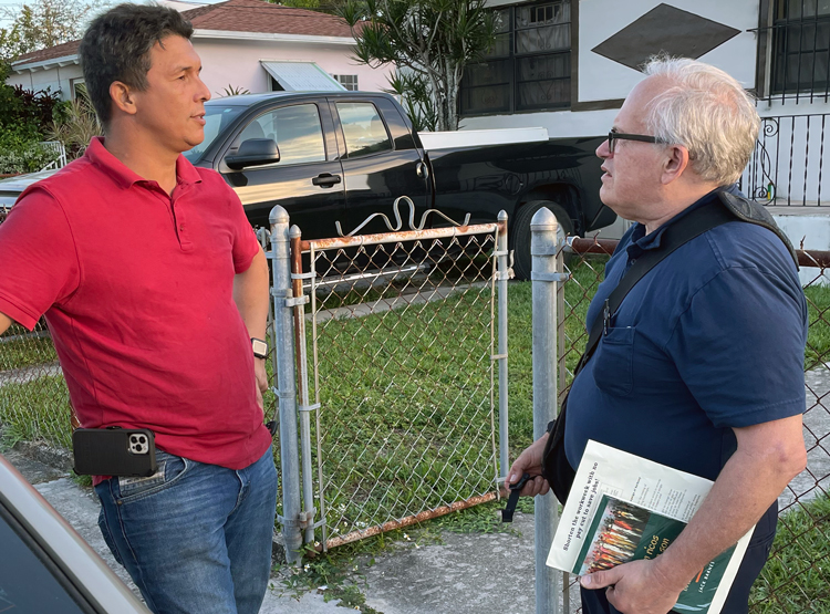 SWP campaigner Chuck Guerra, right, talks with David Marquez, a welder in Miami, Nov. 8. Marquez, who immigrated from Venezuela, bought Are They Rich Because They’re Smart?