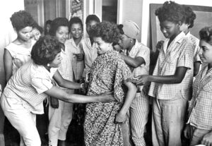 Students at Cuba’s Ana Betancourt School in early 1960s learn to measure and cut fabric. Set up by revolutionary government, school gave job training to peasant women for first time. Inset, Vilma Espín, a leader of the revolution, in 1958.